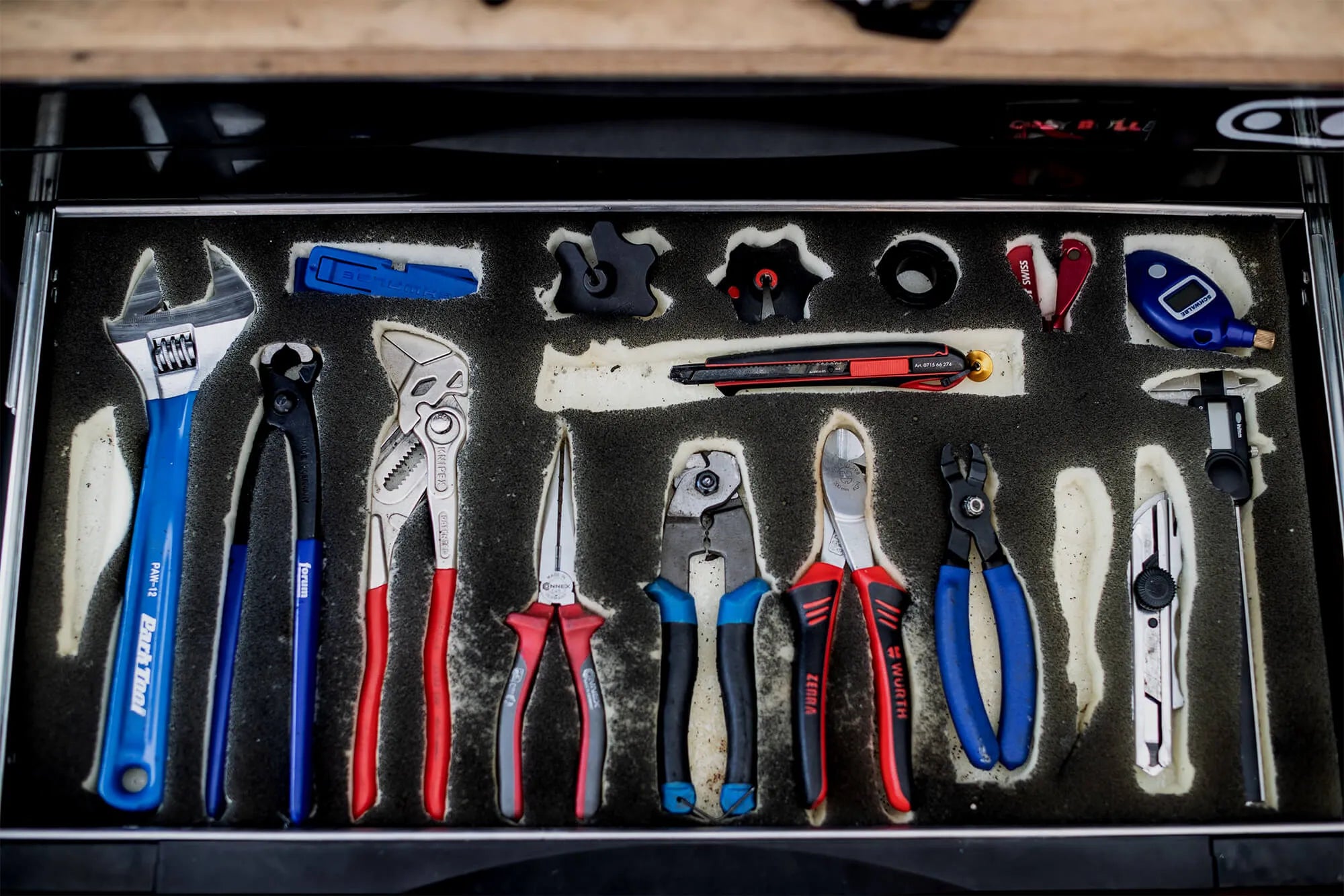 Professional bicycle maintenance tools neatly organized in a foam-lined workshop drawer.
